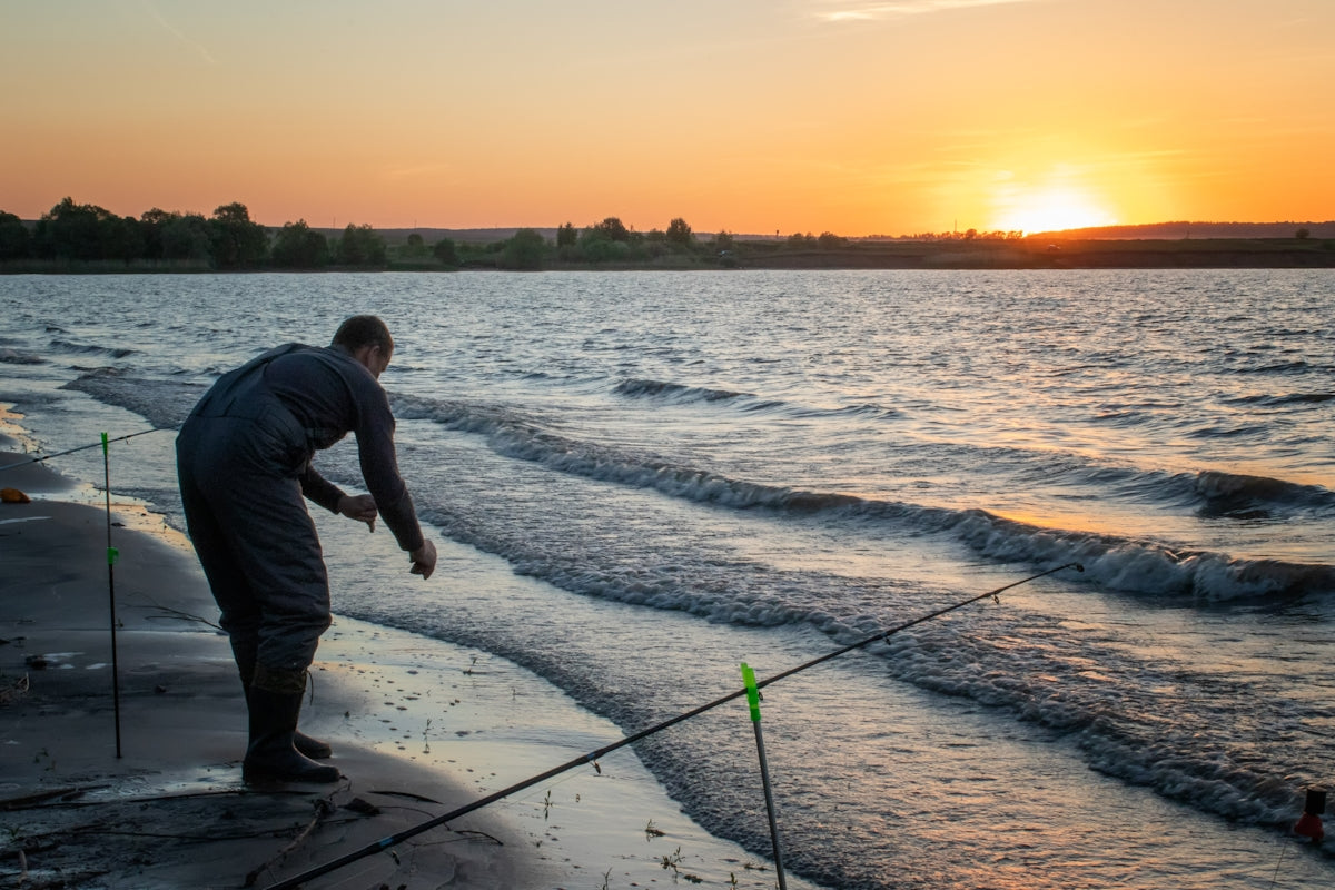 man pole fishing in beach at ssundown