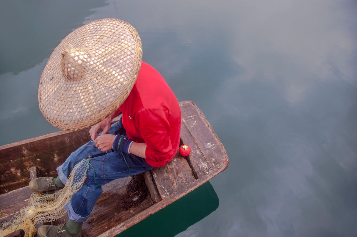 man sitting on canoe