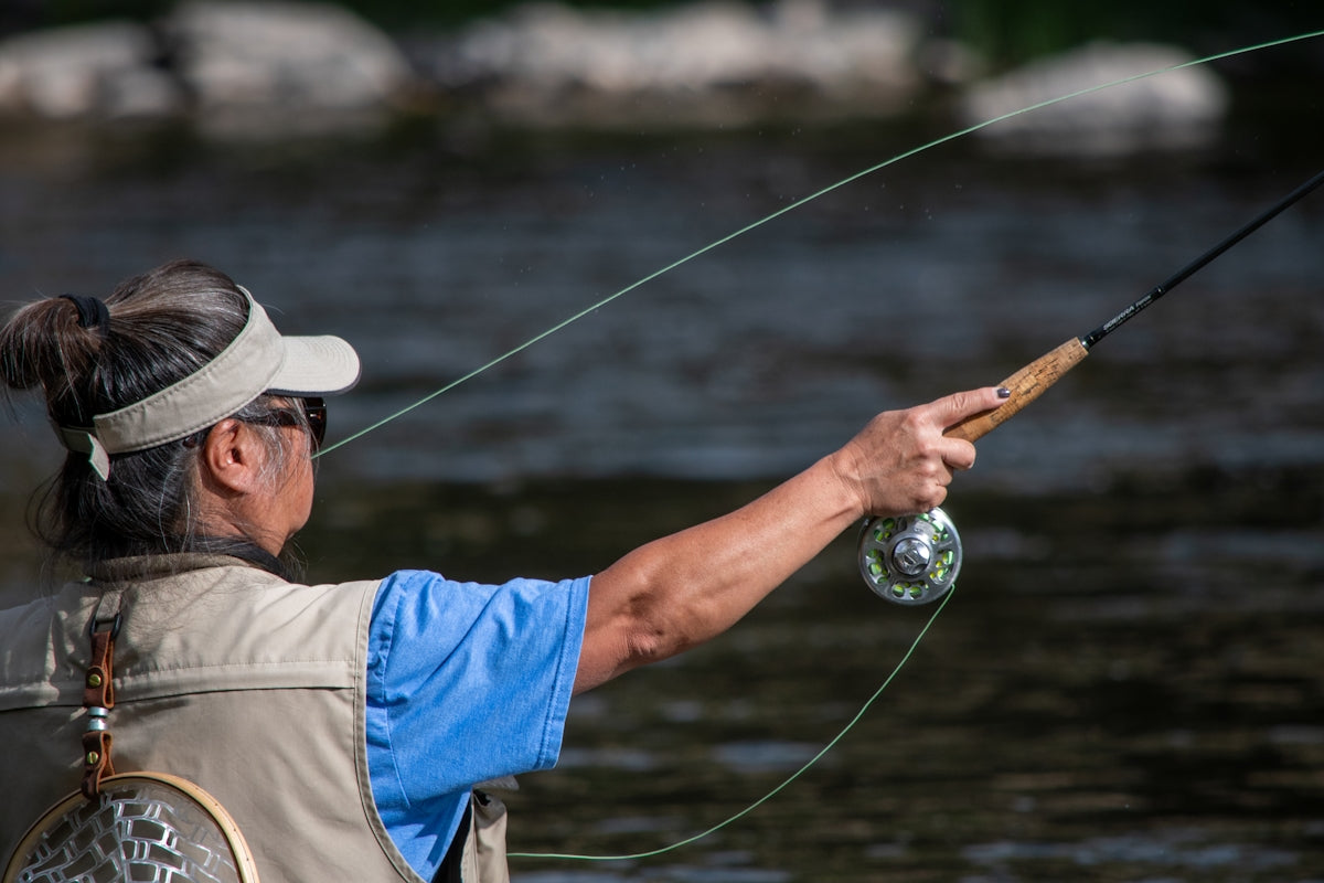 Person using 4 mm Braided Lead Core Rope while fishing by the water in a sunny outdoor setting.