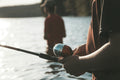 woman holding black and silver fishing rod