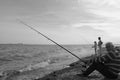 grayscale photo of 2 men fishing on sea