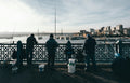 people sitting on black metal chairs near body of water during daytime