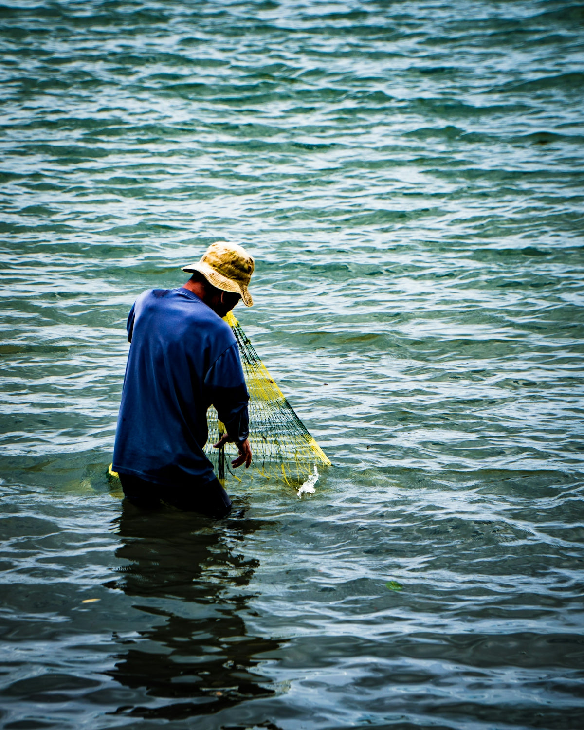 a man standing in a body of water holding a net