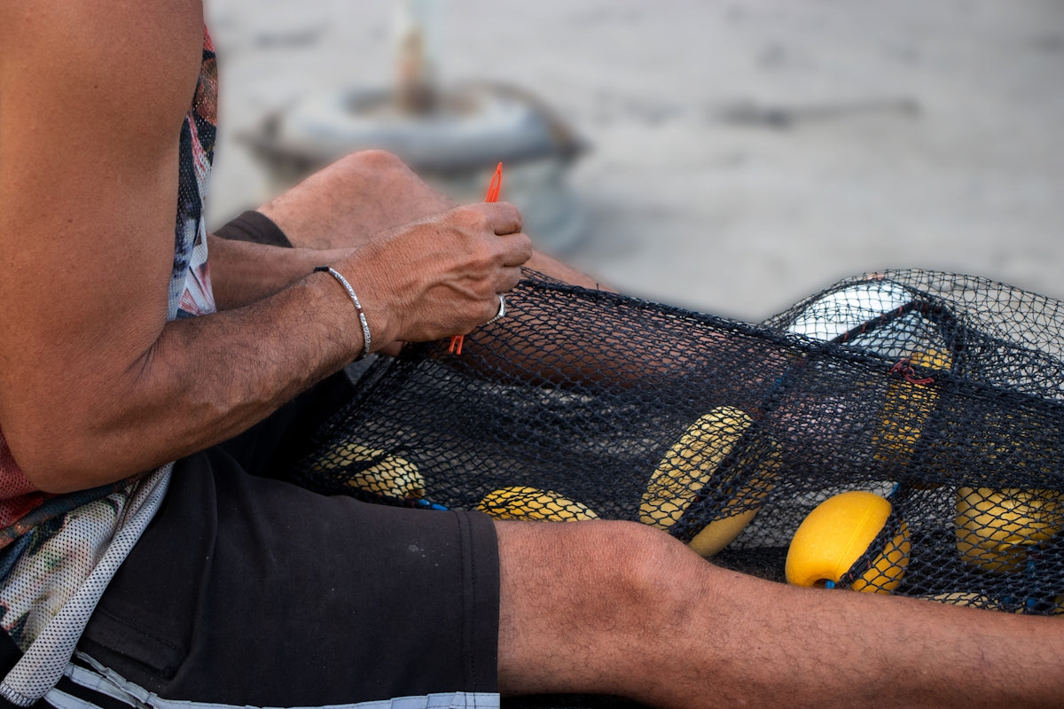 How to Choose the Perfect Unslung Mono Flounder Mesh for Fishing - man preparing a fishing net.