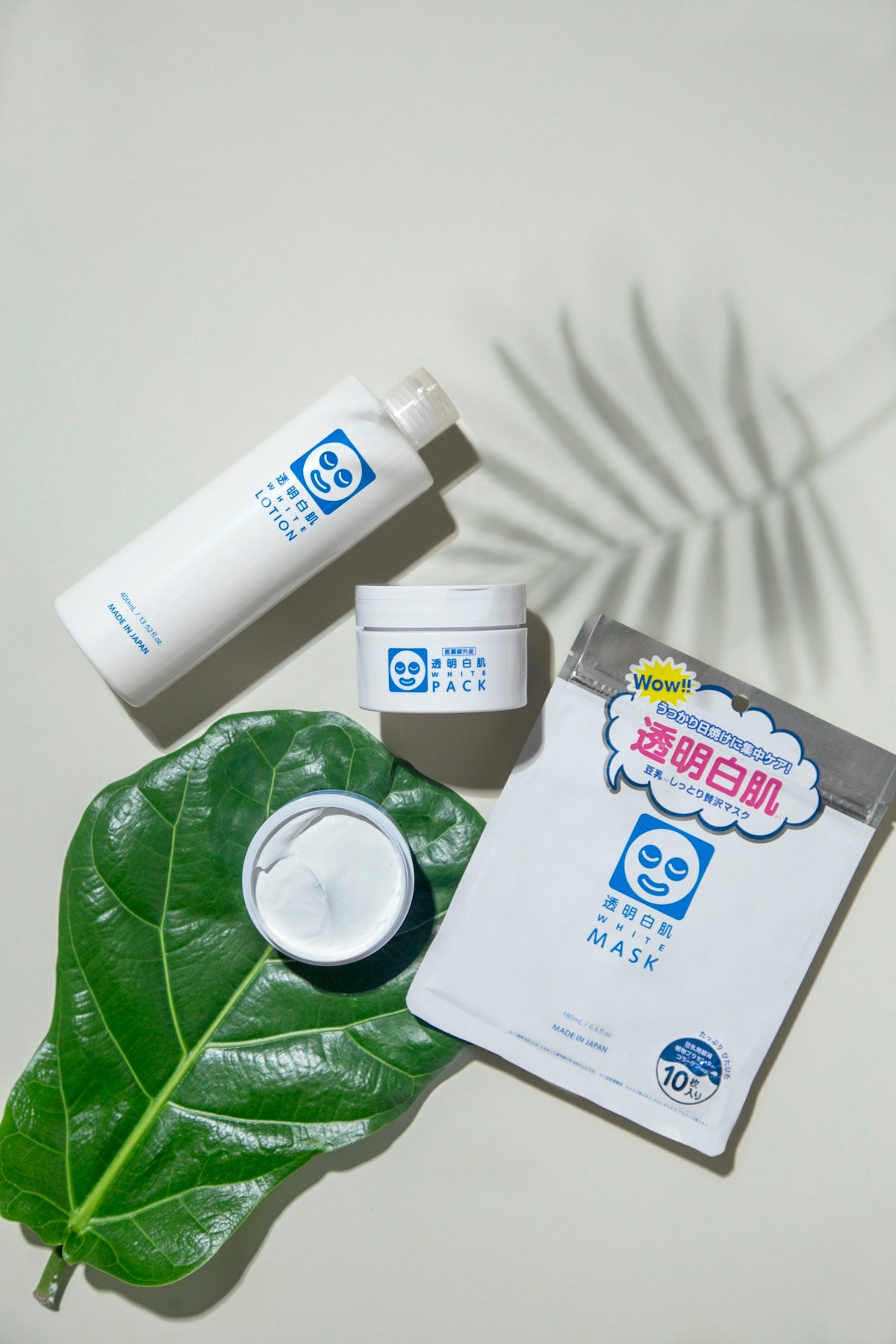 a white towel and a green leaf on a white towel