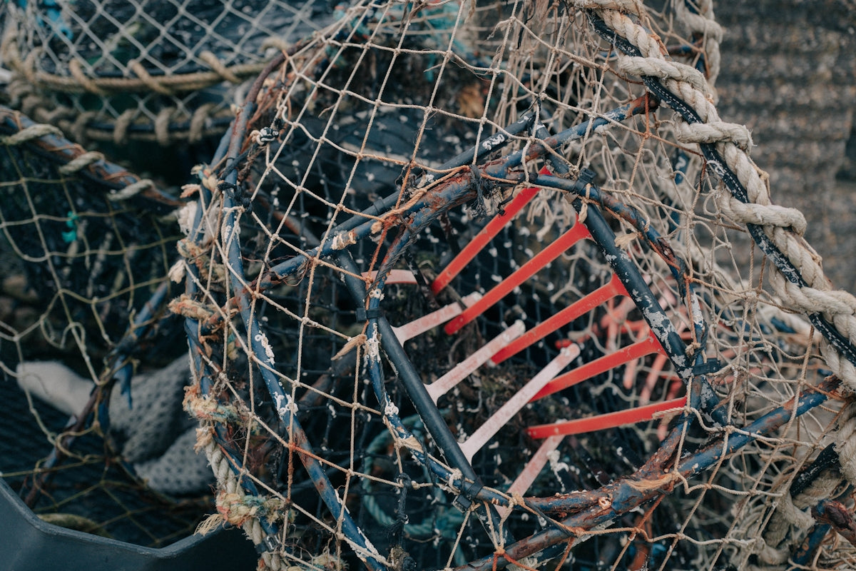 a pile of fishing nets sitting on top of a beach