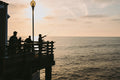 a group of people fishing off of a pier
