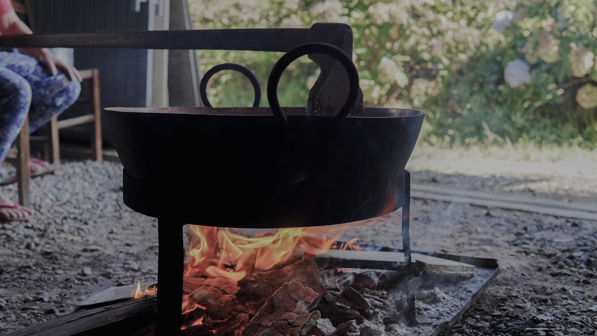 a pot on a fire with a pair of scissors on top of it