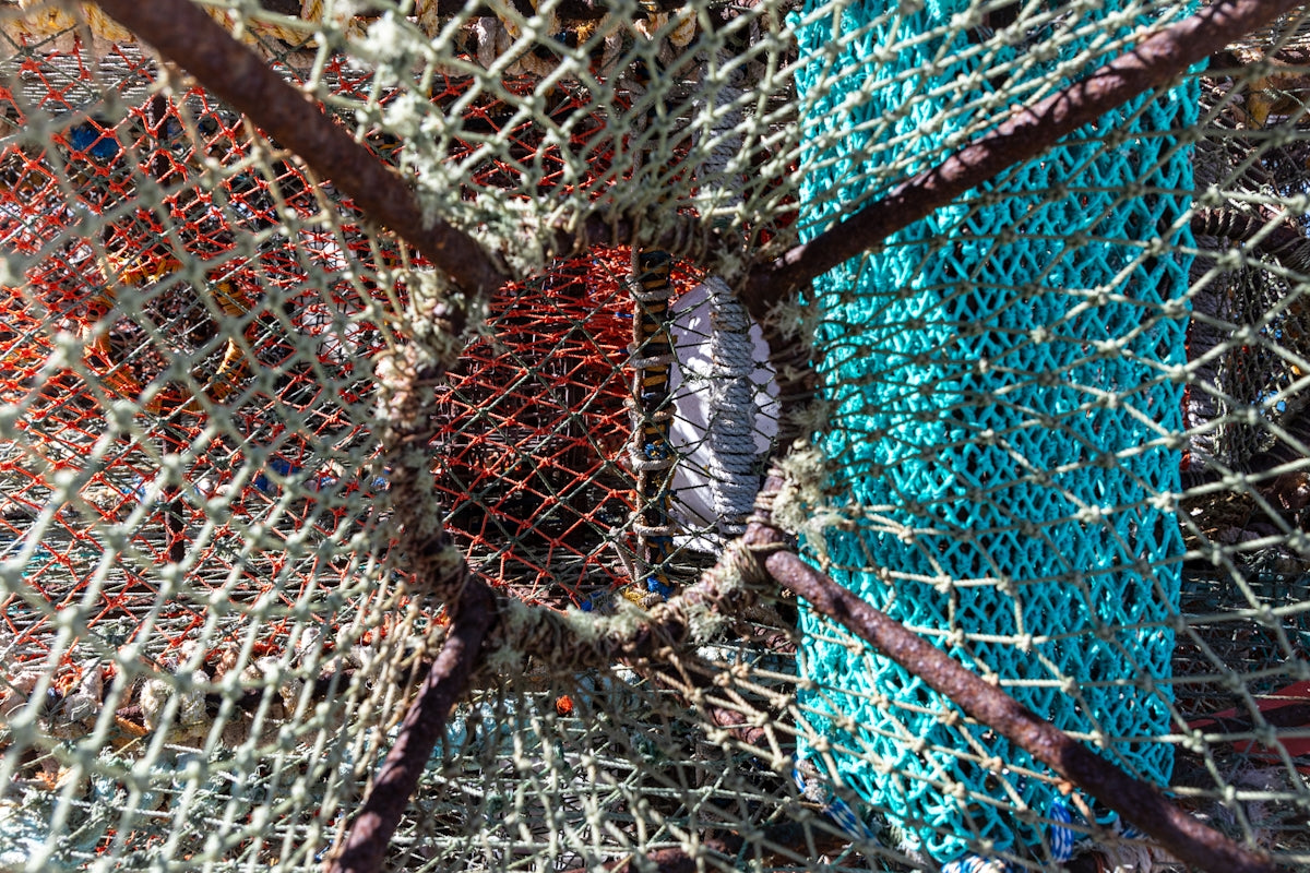 A pile of colorful fishing nets sitting on top of a beach