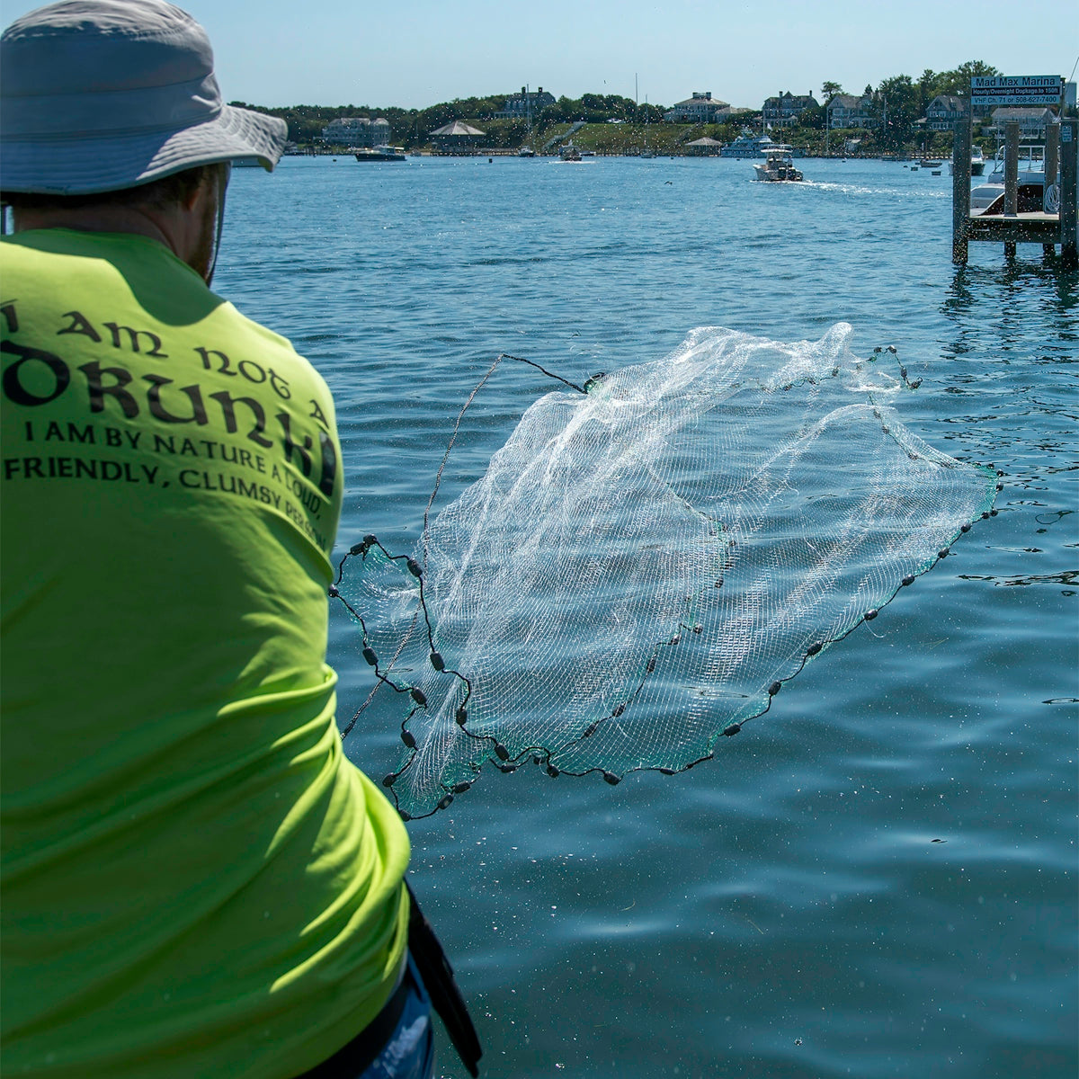 Person using a cast net over water, demonstrating unslung mono flounder mesh applications in fishing.