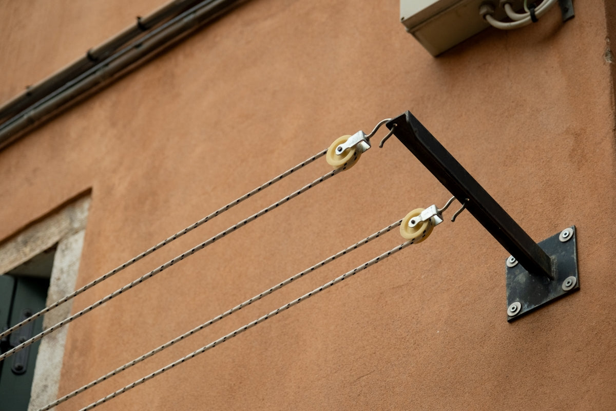 Clotheslines are on a terracotta wall.