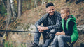 Father and son fishing together at a lake