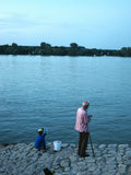 Man and child fishing by the water