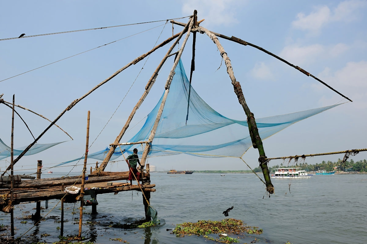 Chinese fishing nets at a pier with a boat.