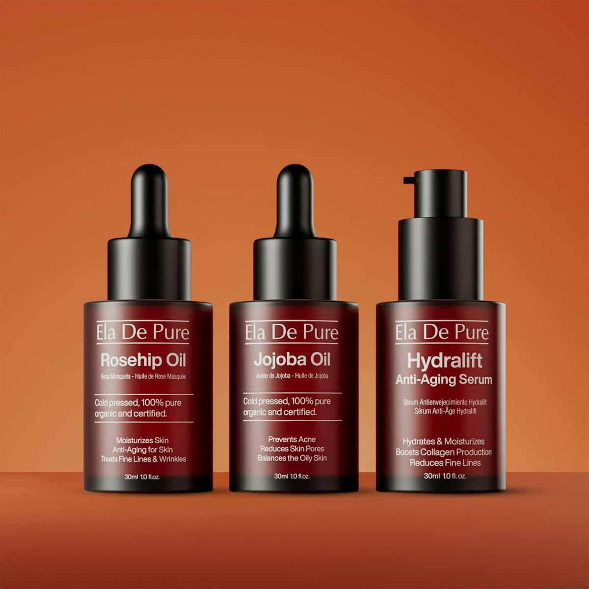 Three bottles of facial serum on orange background