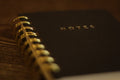 A black notebook with a gold spiral binding.