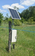 A solar panel powers an electric fence in a field