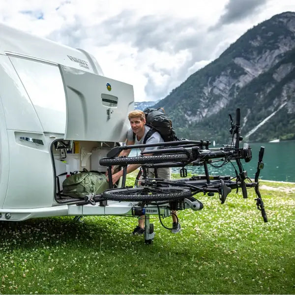 Thule Caravan Superb XT Bike Rack - Short Frame - Anodised with bikes on a caravan by a lake