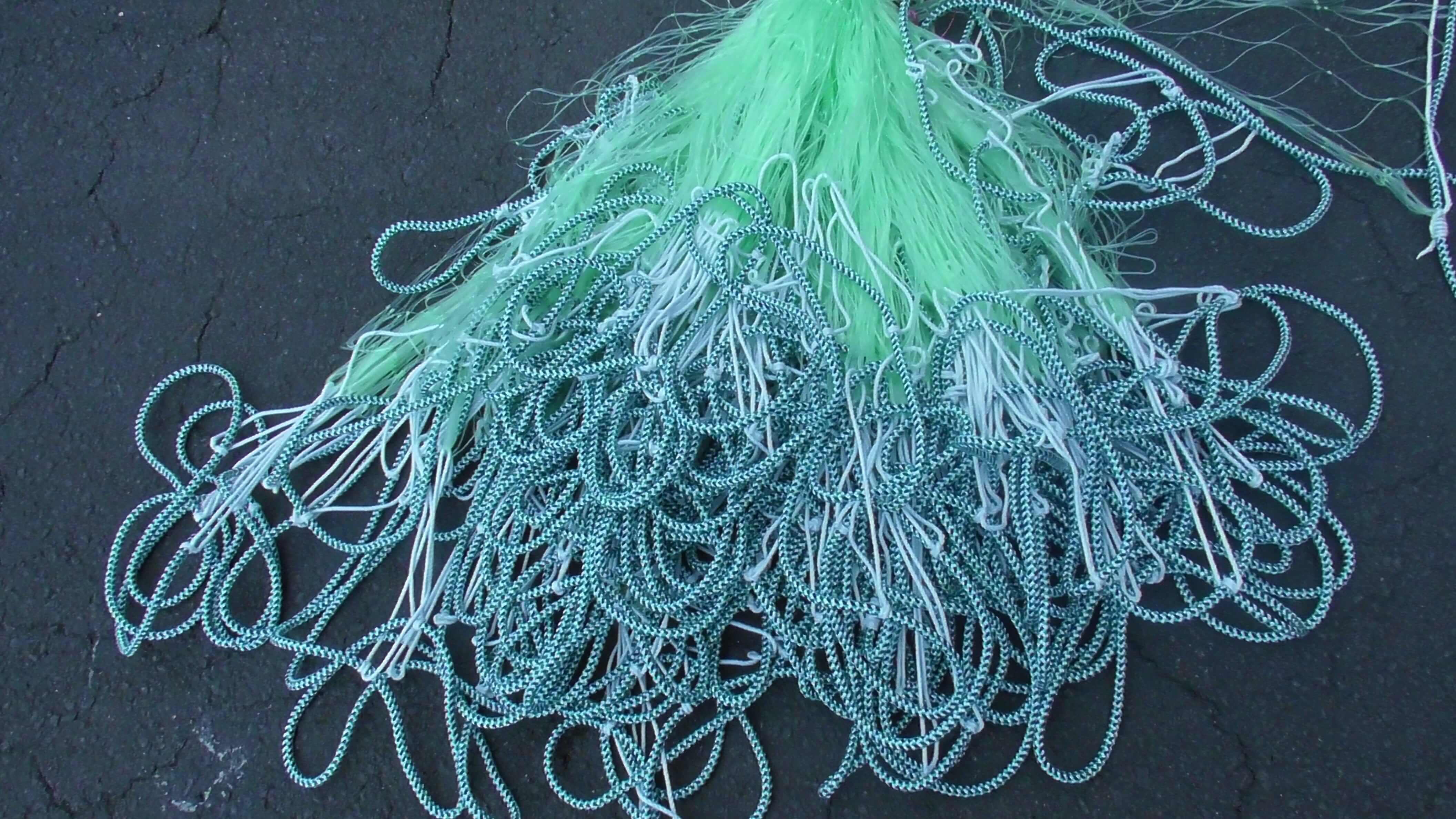 60m Floating Mullet with 90mm Multi Mono Mesh tangled in a large pile on a dark surface.