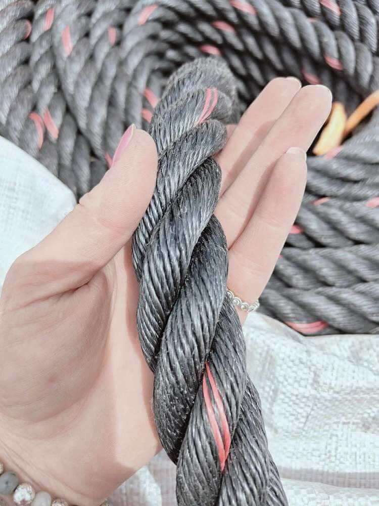 32mm SuperTec Black Rope 4 Strand Sold by the Meter held in hand, showcasing heavy-duty construction and durability.