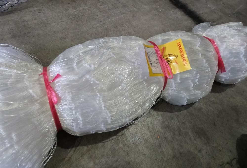 Bait Net Mesh 65mm Mono – 2-1/2 Inch clear fishing netting roll with red ties.