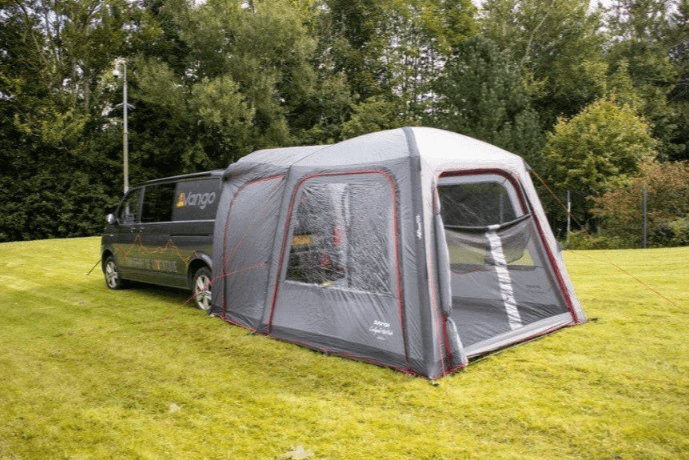 Get Ready for Summer Camping Fun with a cozy tent setup next to a camper van in a green meadow.