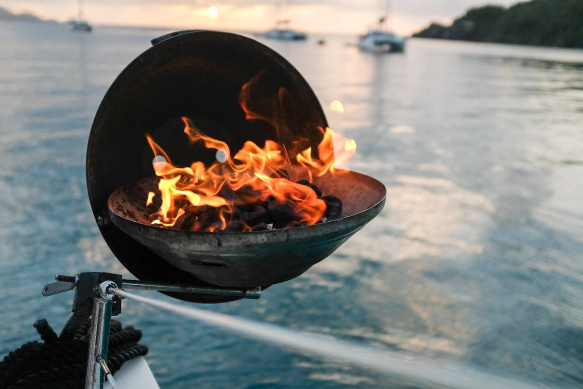 Force 10 4 Burner Gimballed Oven with flames on a boat in the ocean.