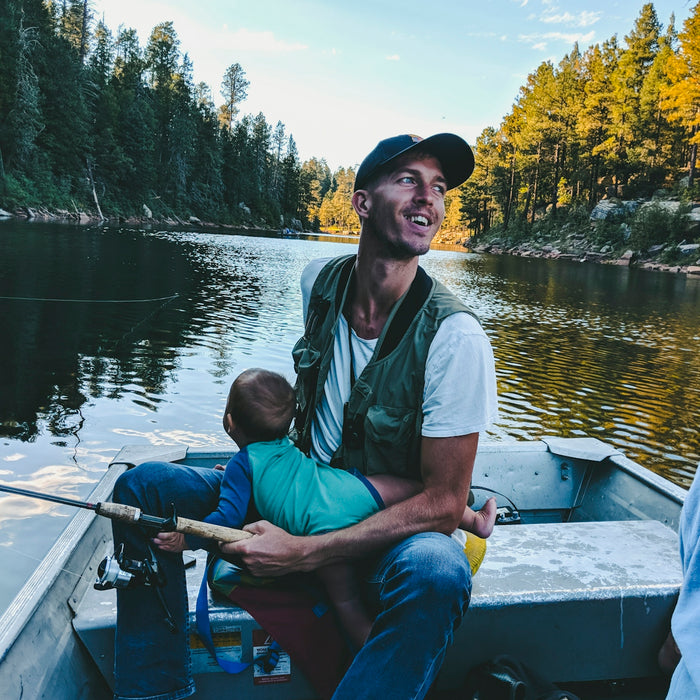 man riding on boat while carrying baby