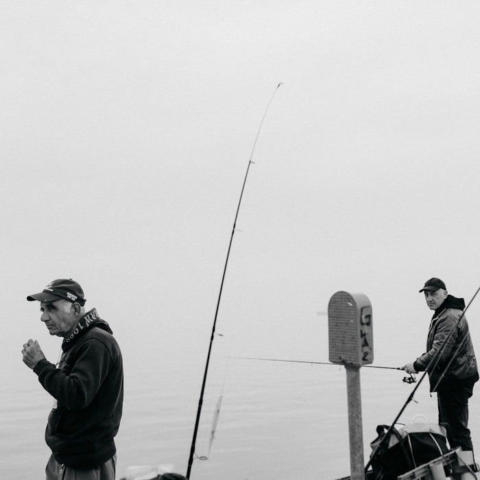 man in black jacket and gray cap holding black dslr camera