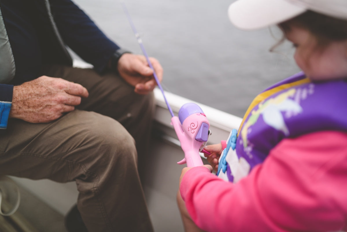 person in pink jacket holding purple stick