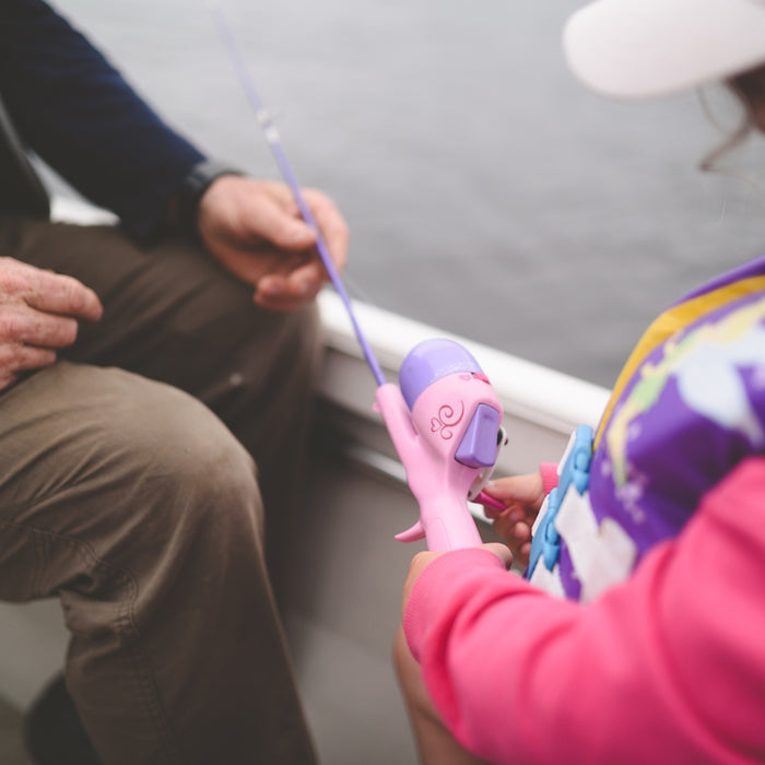 person in pink jacket holding purple stick
