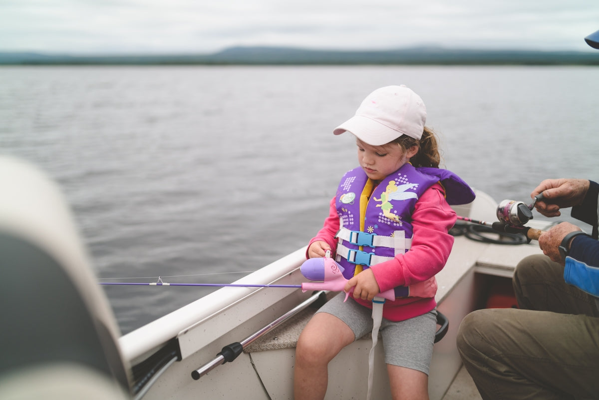 woman in blue and red jacket sitting on boat during daytime