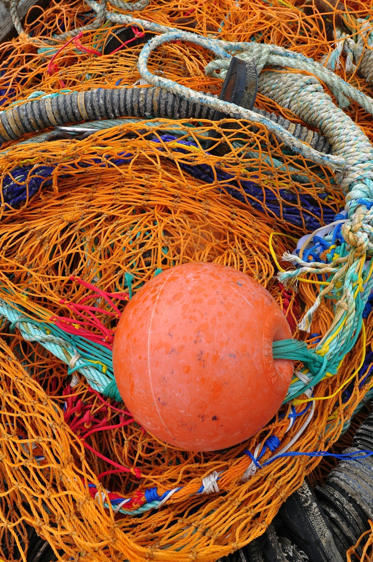 a orange ball sitting in a pile of fishing nets