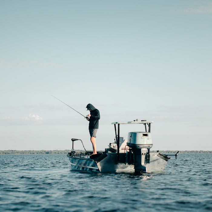 a man standing on top of a boat while fishing