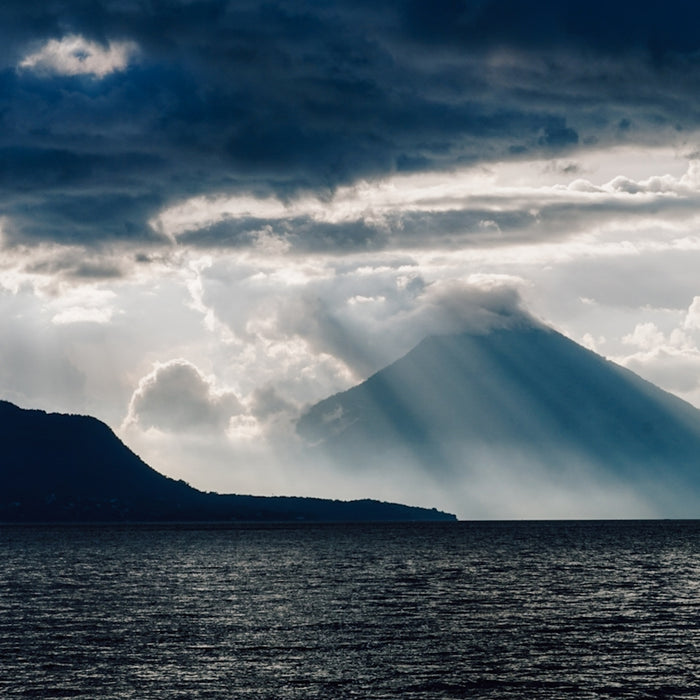 a large body of water with a mountain in the background