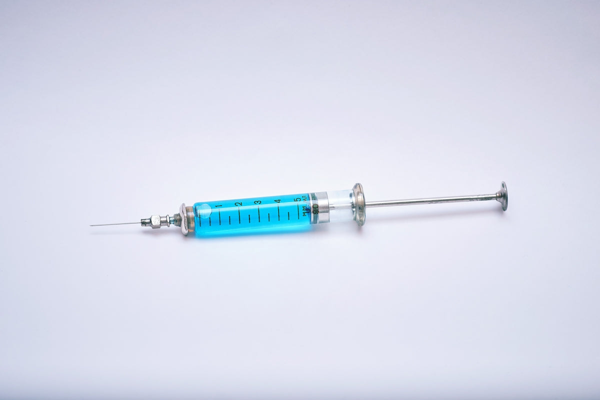 a blue and silver medical instrument on a white surface