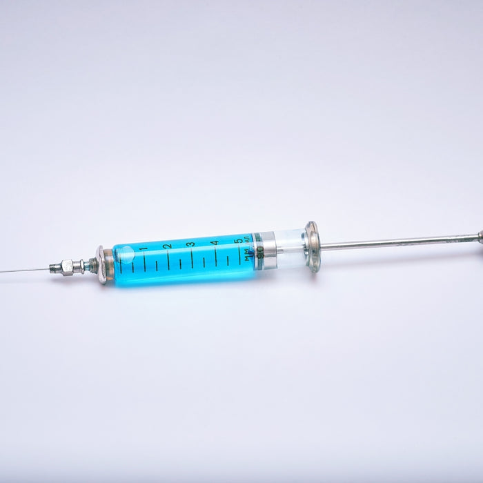a blue and silver medical instrument on a white surface