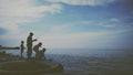 a group of people standing on top of a pier next to the ocean