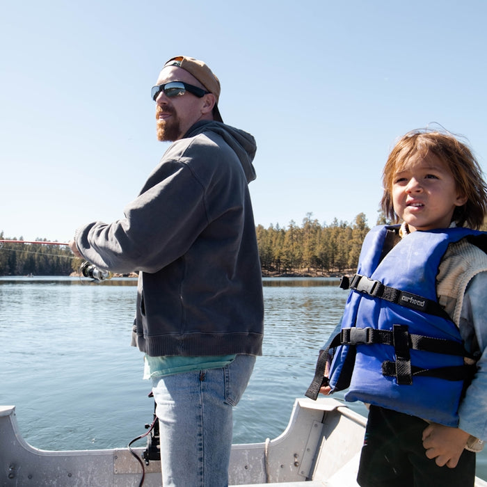a person and a girl on a boat in a lake