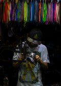 a man holding a camera in front of a wall of ribbons