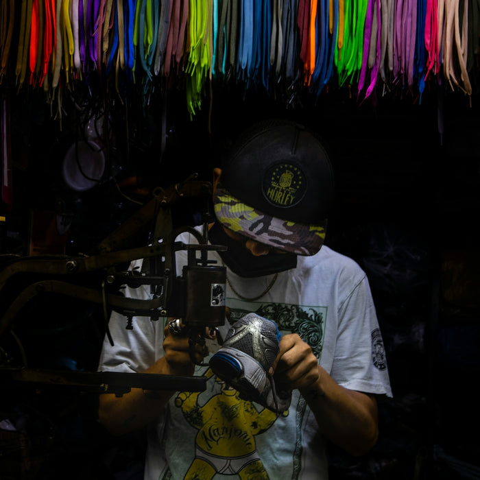 a man holding a camera in front of a wall of ribbons