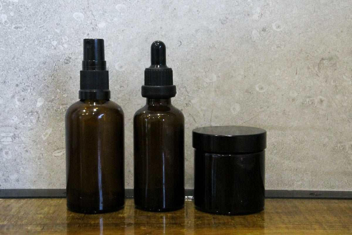 a couple of brown bottles sitting on top of a wooden table