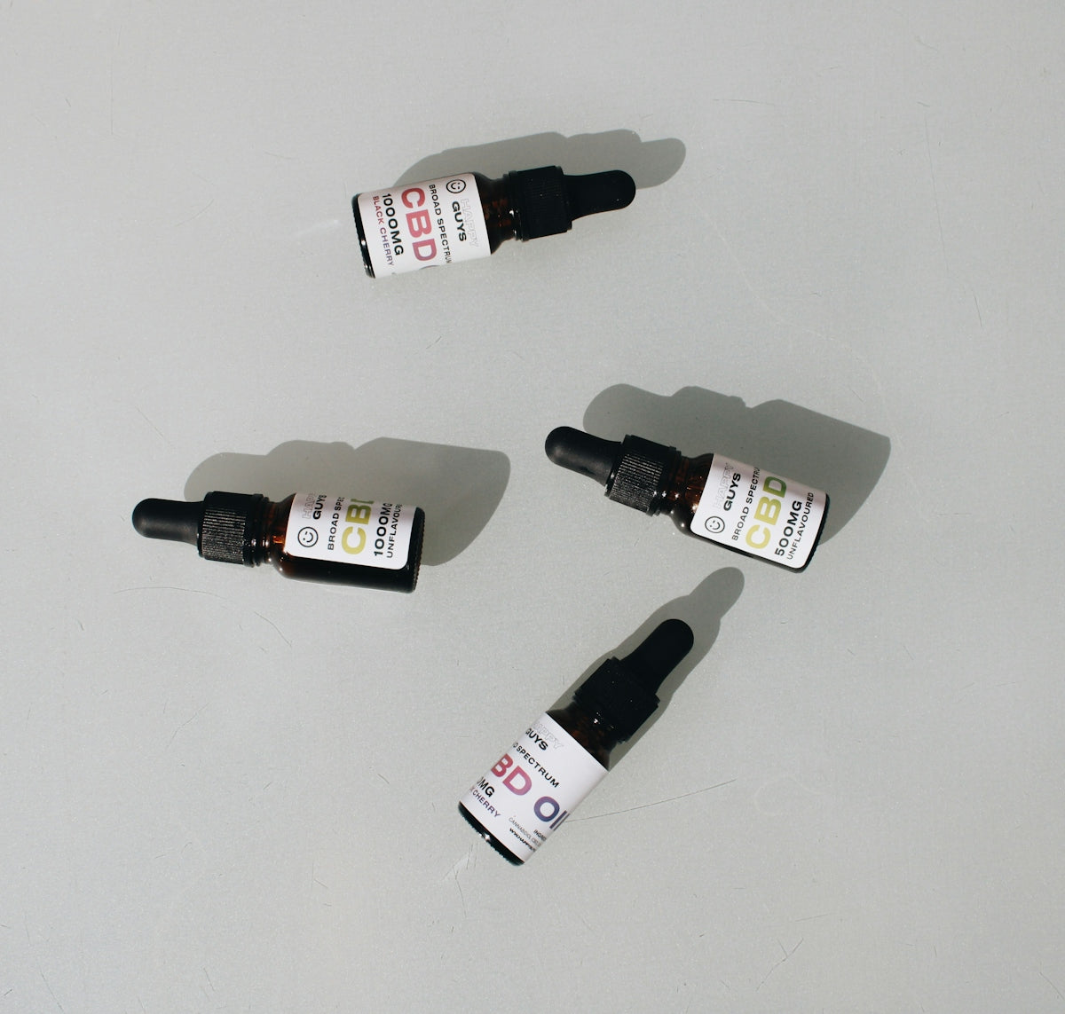 Historical Evolution of CRC Products, four CBD oil dropper bottles placed on a light surface.