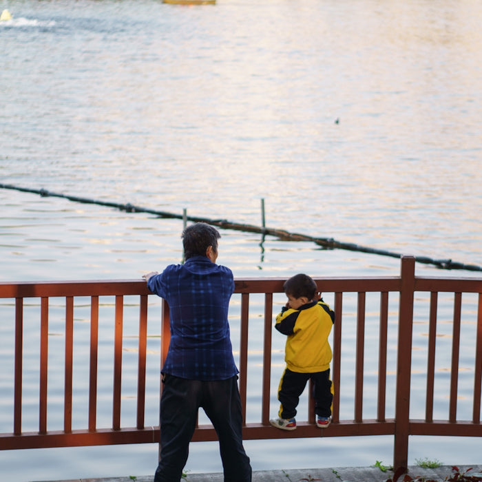 a man standing next to a little boy near a body of water
