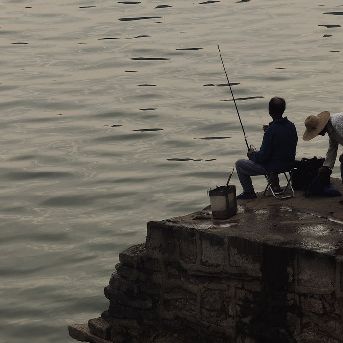 a man and a woman fishing on a pier