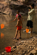 a man standing next to a little girl in a river