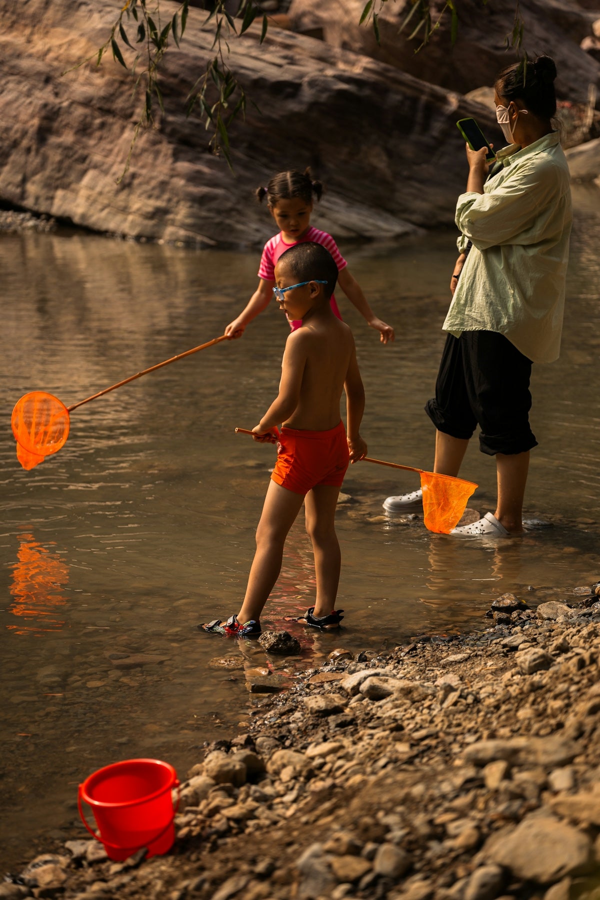 a man standing next to a little girl in a river