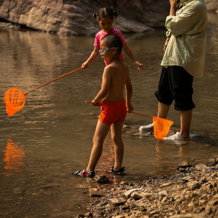 a man standing next to a little girl in a river