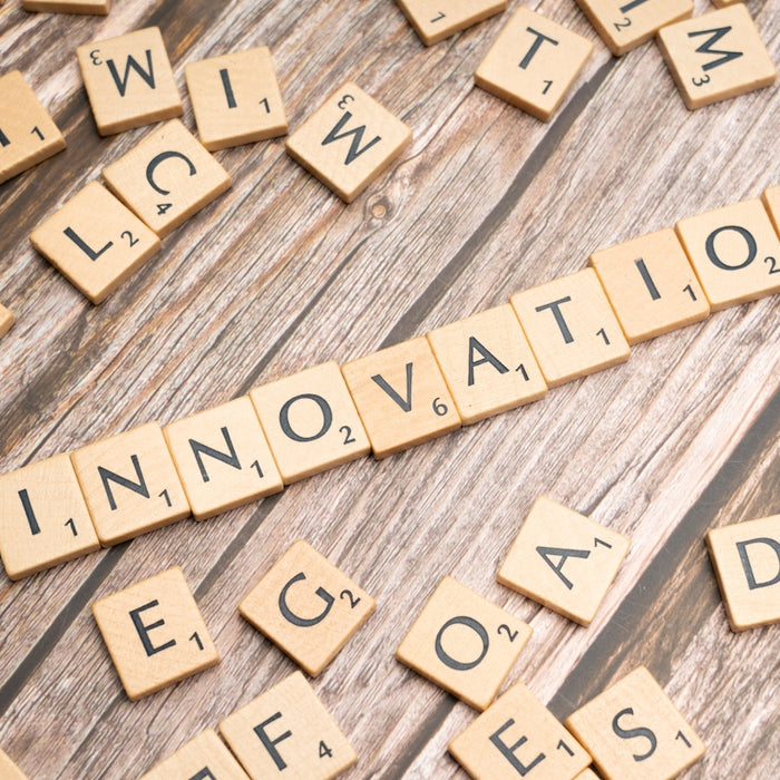 scrabble tiles spelling the word innovation on a wooden surface
