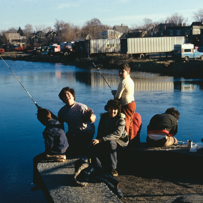 a group of people sitting on a dock fishing